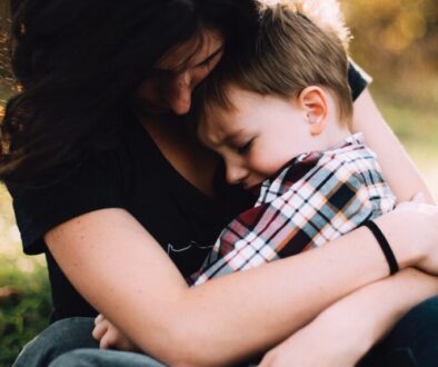 woman hugging boy on her lap