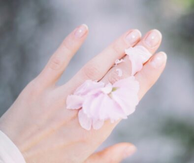 person with pink bow on hand selective focus photography