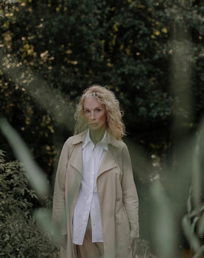 Woman Wearing a Coat Standing Near Plants