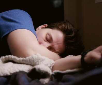 woman in blue shirt lying on bed