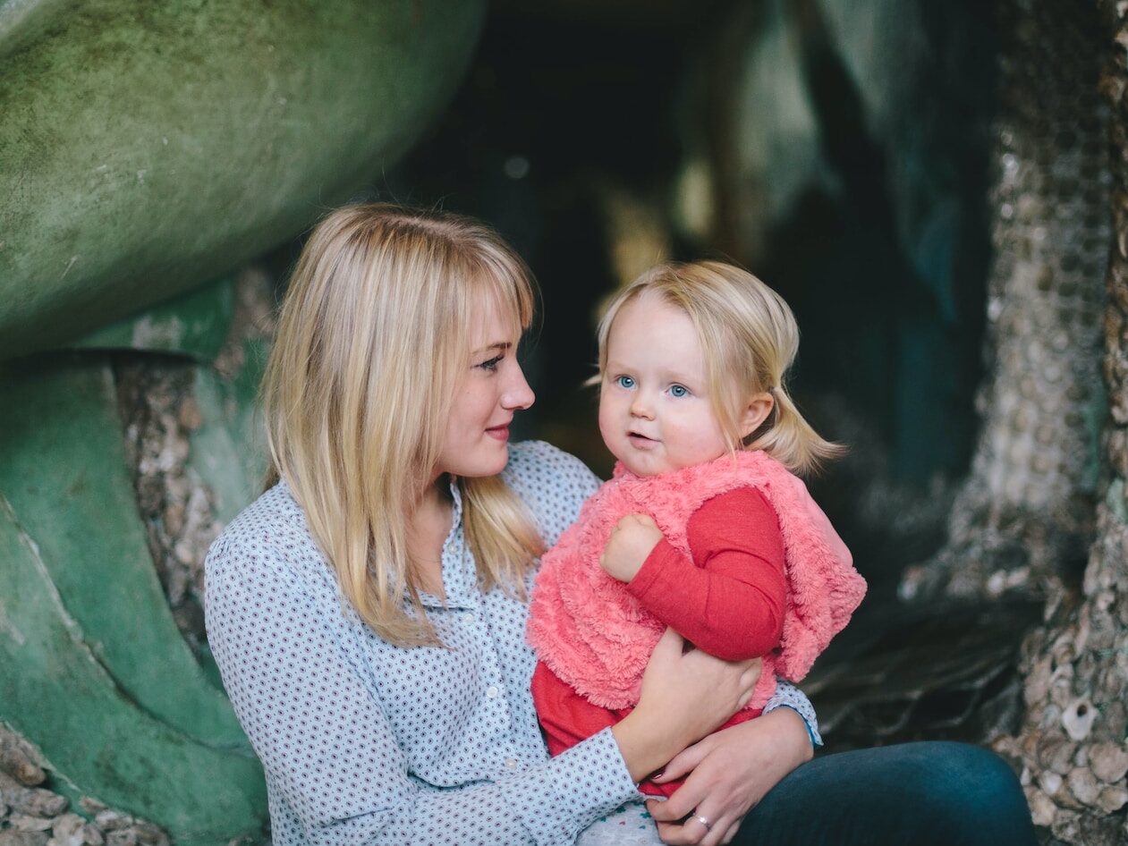 woman holding child while sitting down