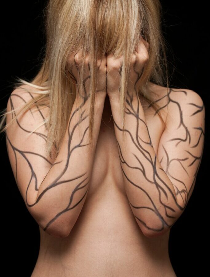 topless woman with black back tattoo