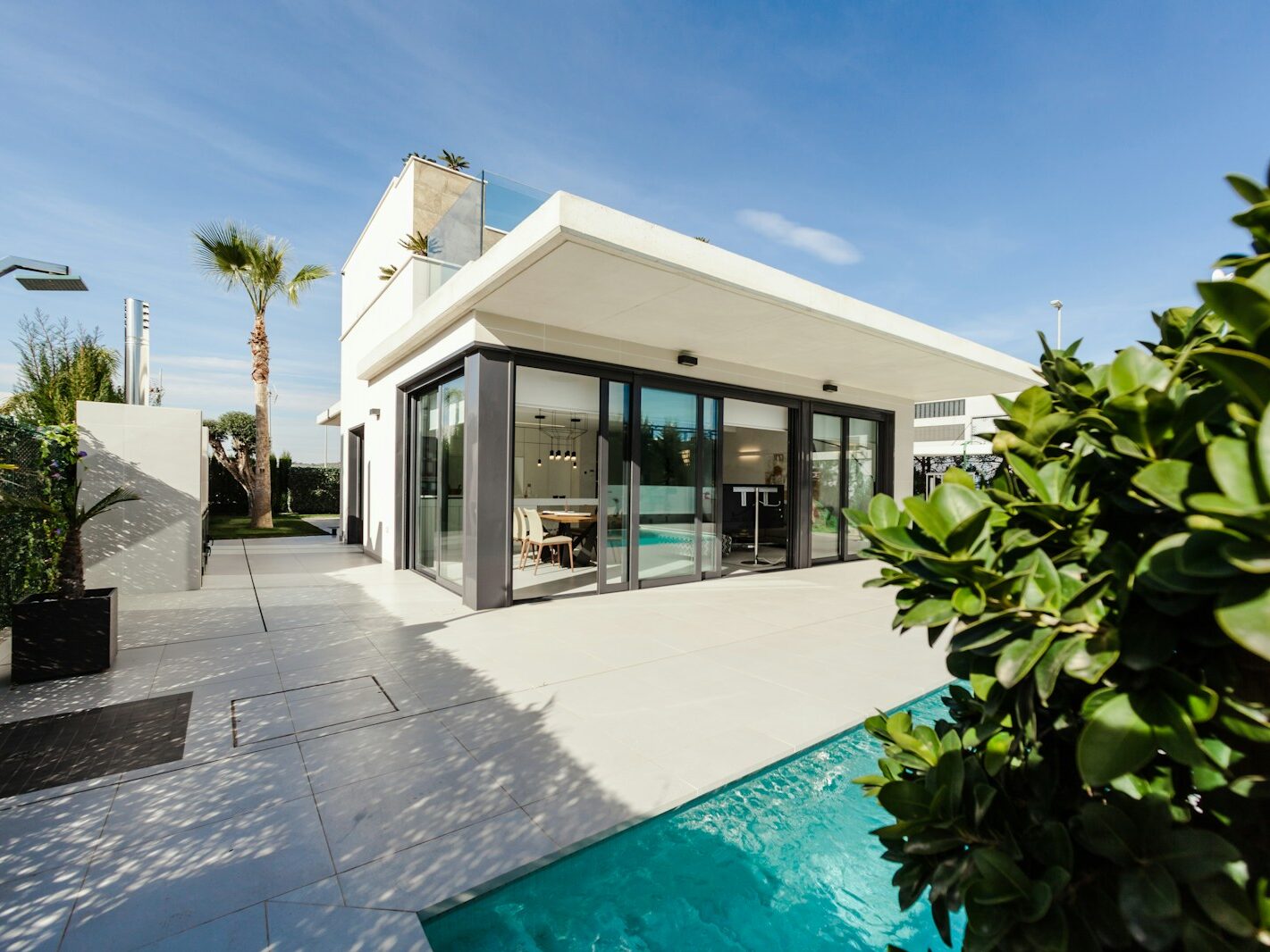 white and grey concrete building near swimming pool under clear sky during daytime