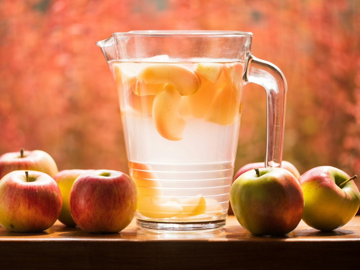 glass pitcher and apples on table