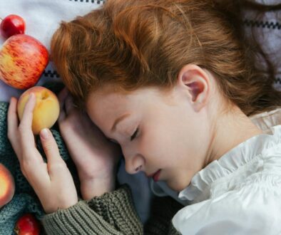 Woman Lying Down with Closed Eyes and Holding Apple