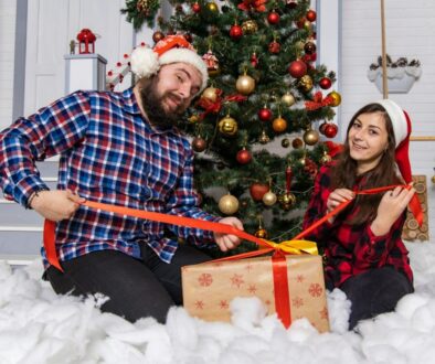 man and woman sitting on white snow