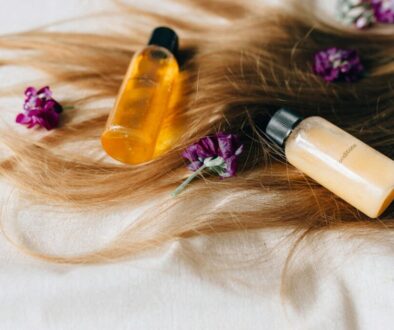 Hair care products on a bed of hair and flowers, symbolizing luxury and beauty.