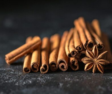 Close-up of cinnamon sticks and star anise on a dark, textured surface, evoking warm, aromatic flavors.