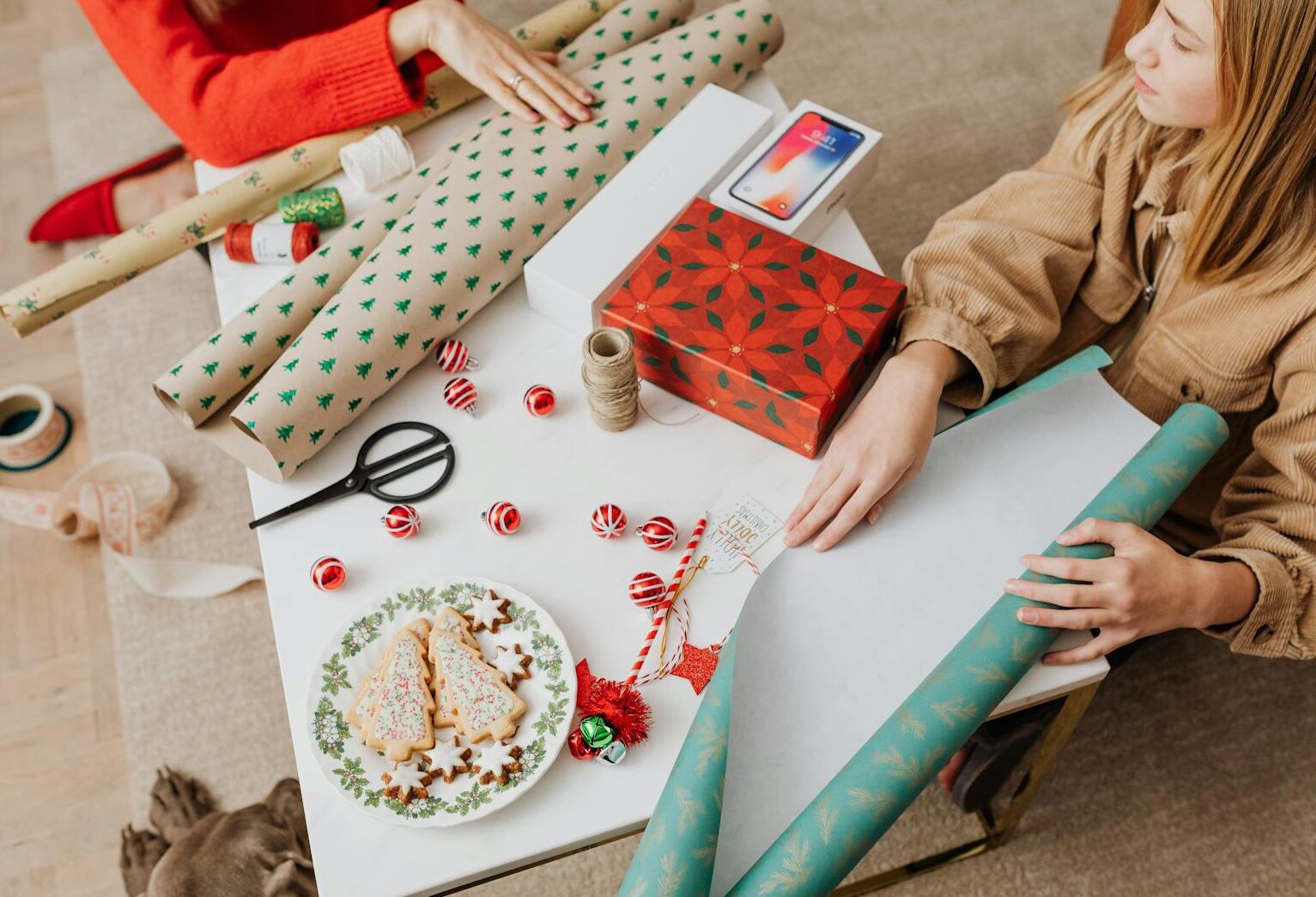 Festive setup showcasing Christmas gift wrapping and decorated cookies, perfect for holiday inspiration.