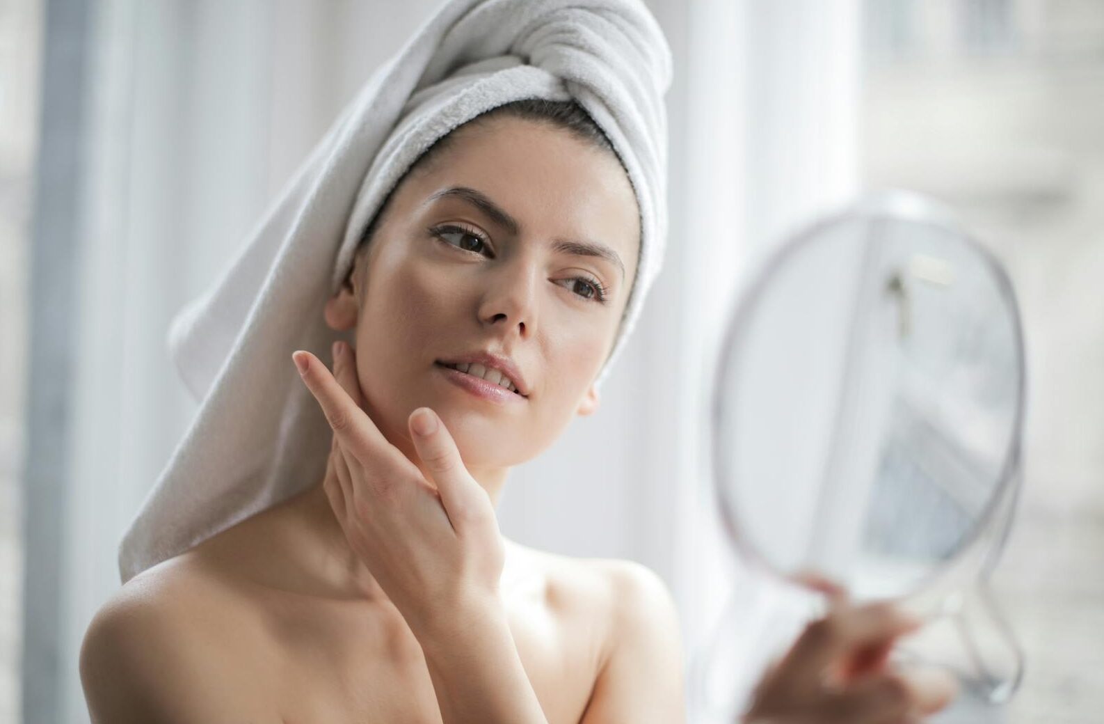 A serene and elegant woman enjoys a skincare ritual, enhancing her natural beauty in the comfort of her home.