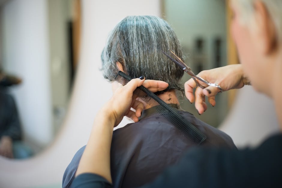 Close-up of a hairstylist cutting a client's hair in a salon.