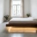 Minimalist bedroom with a floating wooden platform bed, warm under-bed lighting, beige curtains, and potted plants.