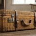 Vintage wicker suitcase with leather straps on a wooden floor.
