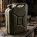 Olive-green 20L WWII-era Wehrmacht jerry can on a dusty workbench with cobwebs in a dim workshop