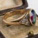 Antique gold ring with an oval multicolored gemstone in a worn velvet jewelry box