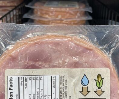 Pre-packaged sliced ham in a vacuum-sealed tray with a nutrition facts label visible on the front.