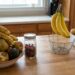 A kitchen island with bowls of fruit: bananas, apples, pears, and avocados, plus a jar of berries on the counter.
