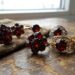 Set of vintage rings with dark red gems arranged on a rustic wooden surface near a window.
